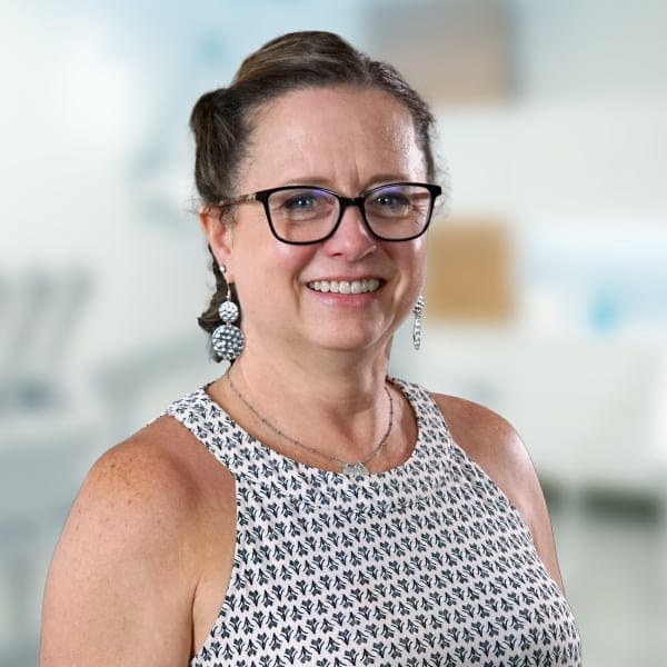 Jennifer Scirocco smiling, standing in a dental treatment room