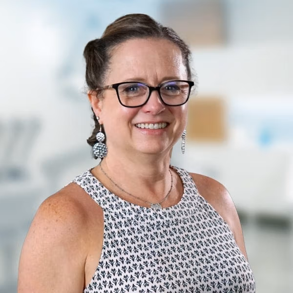 Jennifer Scirocco smiling, standing in a dental treatment room